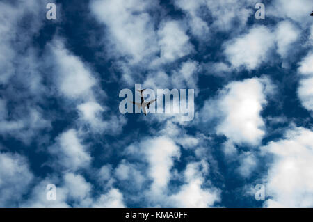 Piano volare nel cielo nuvoloso Foto Stock