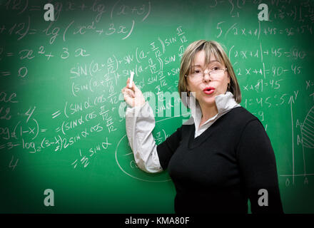 Insegnante è in piedi vicino a lavagna in aula Foto Stock