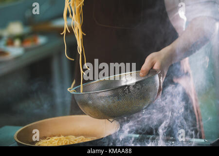 Processo di cucinare gli spaghetti nel ristorante Foto Stock