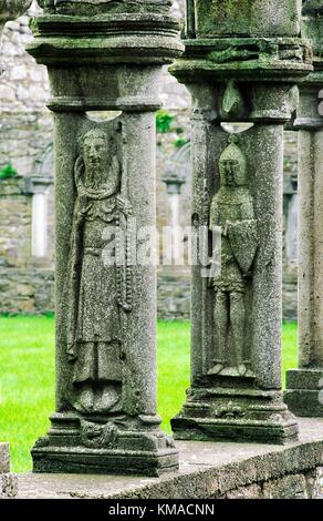 Abbazia di Jerpoint, nella Contea di Kilkenny, Irlanda. Stone figure scolpite sui pilastri del chiostro. Foto Stock