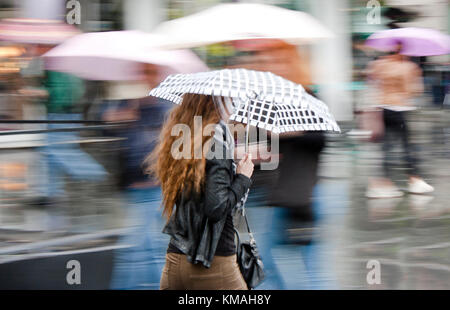 Belgrado, Serbia- Maggio 5, 2017: giovane donna che cammina di fretta sotto un ombrellone e piovosa città sfocate street Foto Stock