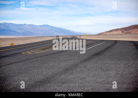 Vuoto area di parcheggio nel parco nazionale della Valle della Morte, Nevada, Stati Uniti d'America in un arido paesaggio arido con montagne in lontananza Foto Stock