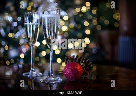 Due bicchieri di champagne circondato da decorazioni di Natale Foto Stock