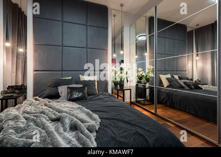 Elegante camera con letto matrimoniale, armadio a specchio e tv Foto stock  - Alamy