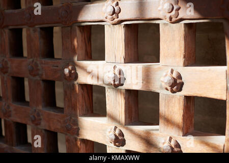 Un vecchio legno robusto portcullis cancello o porta per la protezione di una fortificazione ornato di chiodi in una vista ravvicinata Foto Stock