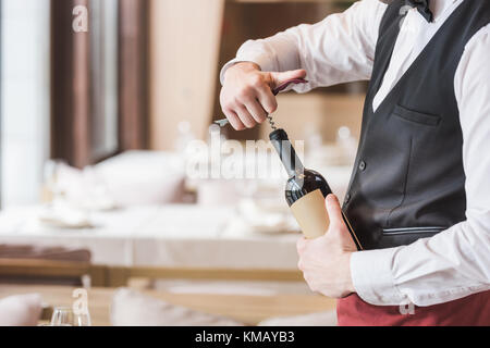 Cameriere di aprire una bottiglia di vino Foto Stock