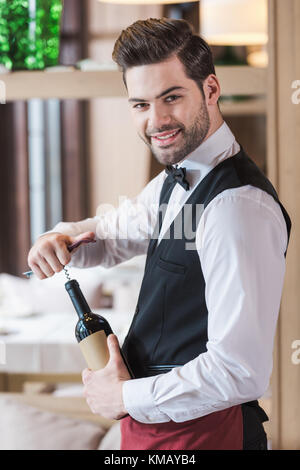 Cameriere di aprire una bottiglia di vino Foto Stock