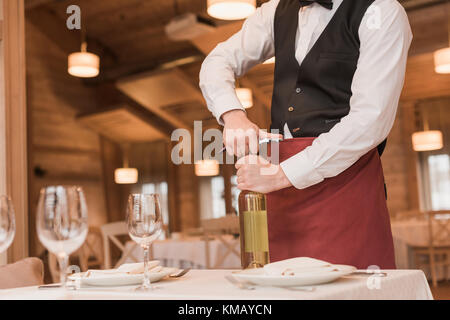 Cameriere di aprire una bottiglia di vino Foto Stock