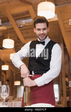 Cameriere di aprire una bottiglia di vino Foto Stock