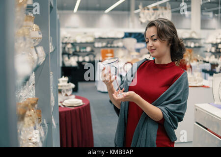 Il cliente la scelta di bicchieri di cristallo arnese piatti nel supermercato mall Foto Stock