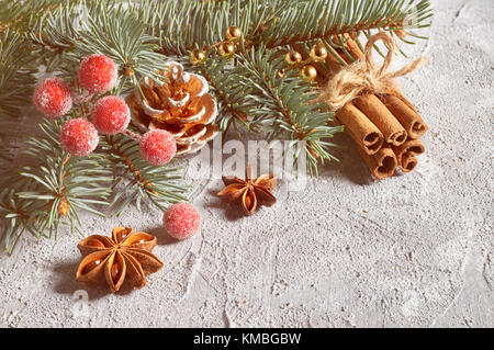 Natale ancora vita decorata con ramoscelli di abete, anice stelle, bastoncini di cannella su sfondo chiaro, spazio di testo Foto Stock