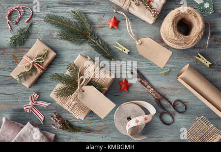 Realizzato a mano regali sul buio tavola in legno rustico con decorazioni di Natale. sfondo stagionale ripresa dall'alto. flat laico, vista dall'alto, immagine filtrata. ta Foto Stock