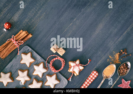 Sfondo di natale in bianco e rosso su legno scuro. vista dall'alto su biscotti di Natale, spezie e decorazioni. tonica immagine, lo spazio di testo Foto Stock