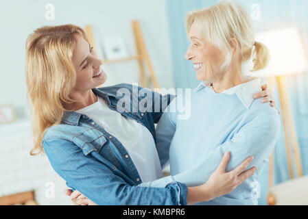 Positive le donne di due generazioni guardando ogni altro e sorridente Foto Stock