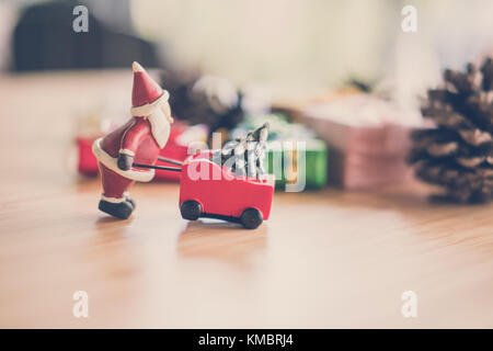 Babbo Natale con albero di natale in carriola. motivi carrello miniatura. vacanze di Natale celebrazione concetto. stagione saluti Foto Stock