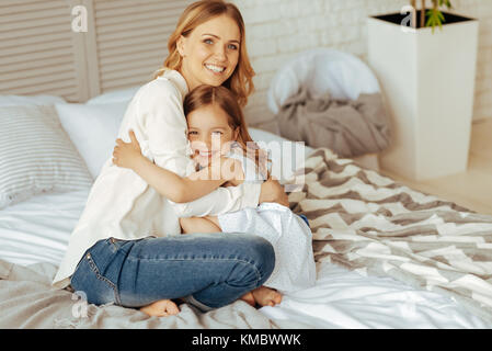 Felice donna positivo abbracciando la figlia Foto Stock