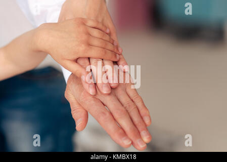 Close up di mani di essere messo su un altro Foto Stock