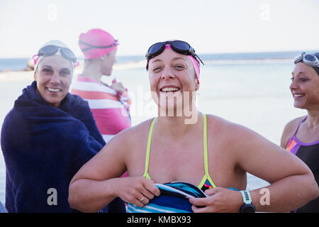 Ritratto sorridente, fiduciosa apertura femmina acqua nuotatori essiccando con asciugamani Foto Stock