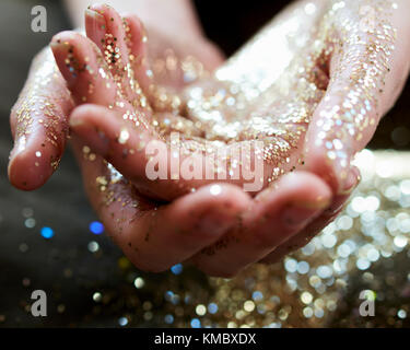 Chiudere fino a mani oro cupping glitter Foto Stock