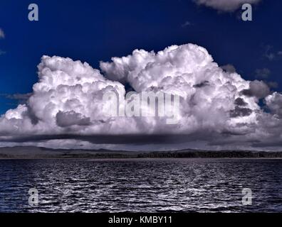 Una spettacolare drammatica vivacemente colorato nuvoloso acqua di mare marina tropicale con awesome billowing white cumulus la formazione di nubi in un cielo blu Foto Stock