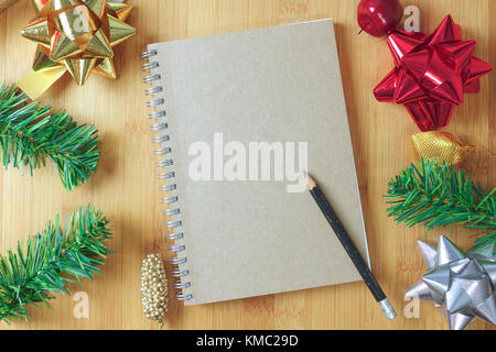Brown book con matita e decorazione di Natale sul tavolo di legno - vista superiore Foto Stock