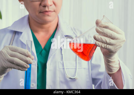 Scienziato maschio mantiene ed esaminare campioni Foto Stock