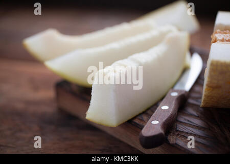 Pezzi freschi di melone su sfondo di legno. Foto Stock