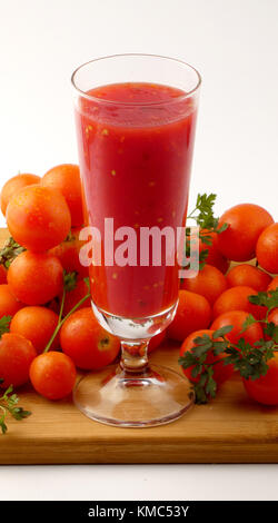 Tamoto succo con pepe e pomodori ciliegia sulla tavola in legno isolato Foto Stock
