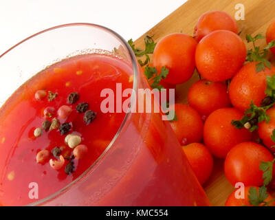 Tamoto succo con pepe e pomodori ciliegia sulla tavola in legno isolato Foto Stock