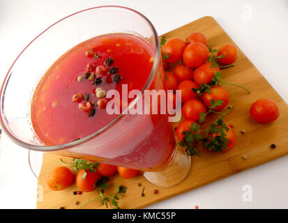 Tamoto succo con pepe e pomodori ciliegia sulla tavola in legno isolato Foto Stock