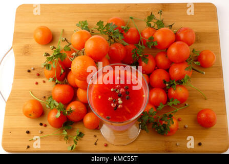 Tamoto succo con pepe e pomodori ciliegia sulla tavola in legno isolato Foto Stock