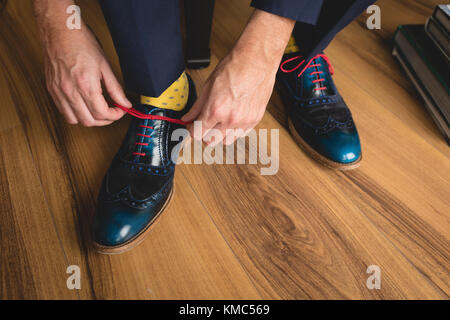 L'uomo la legatura del suo laccio a casa Foto Stock