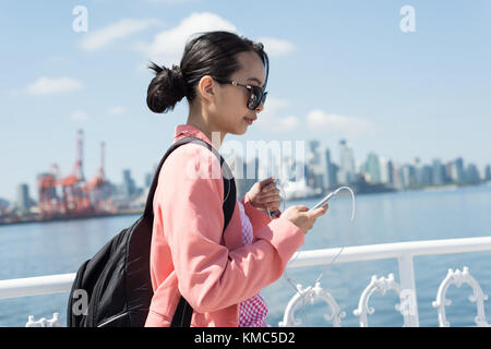 Donna asiatica che usa il suo telefono nel traghetto 4K Foto Stock