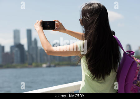 Giovane donna che scatta una fotografia dal traghetto Foto Stock