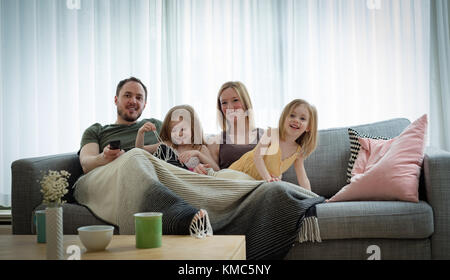 Famiglia di guardare la televisione in salotto Foto Stock