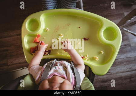 Sovraccarico di baby sitting in sedia alta Foto Stock