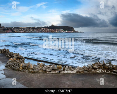 Onde che si infrangono ad alta marea in South Bay con la Collina del Castello oltre a Scarborough North Yorkshire, Inghilterra Foto Stock