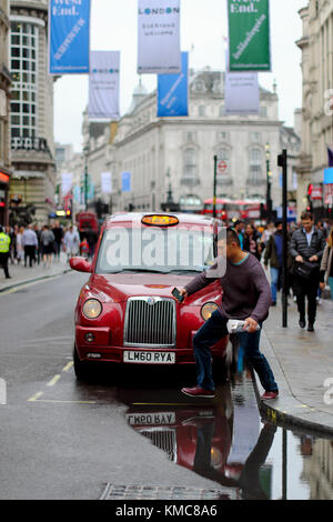 L'uomo saltando su pozza in London, England, Regno Unito Foto Stock