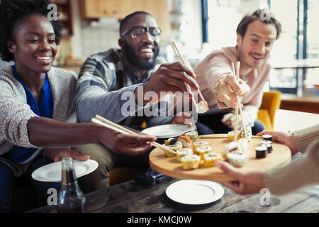 Gli amici gustano il sushi nel ristorante Foto Stock
