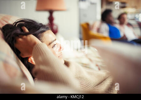 Giovane donna che si rilassa con la mano in capelli sul divano Foto Stock