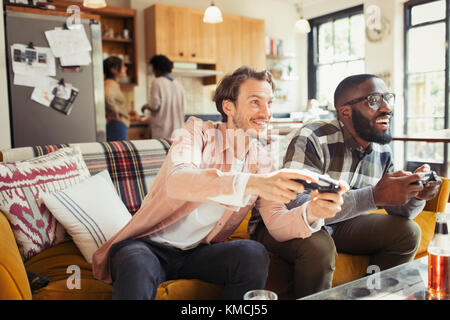 Uomini amici che giocano in un videogioco in salotto Foto Stock