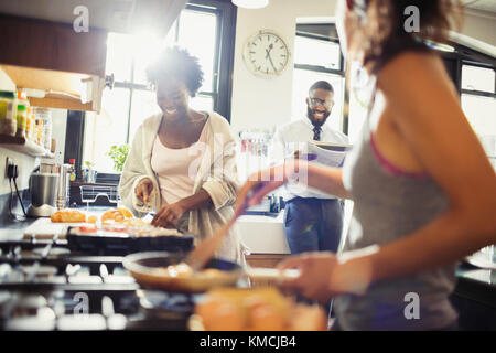 Un amico coinquilini che cucinano la prima colazione in cucina Foto Stock