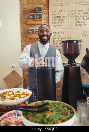 Ritratto sorridente barista maschile che lavora dietro il bancone nel bar Foto Stock