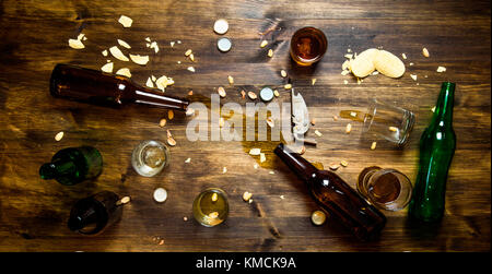 Festa della birra. nel processo di partito - Versamento di birra, i tappi di bottiglia e avanzi di chips sul tavolo. vista superiore Foto Stock