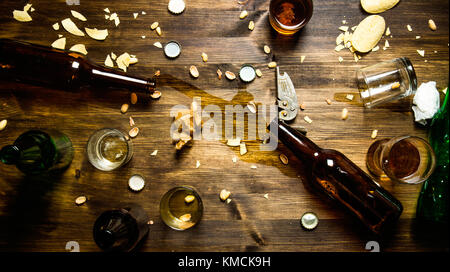 Festa della birra. nel processo di partito - Versamento di birra, i tappi di bottiglia e avanzi di chips sul tavolo. vista superiore Foto Stock