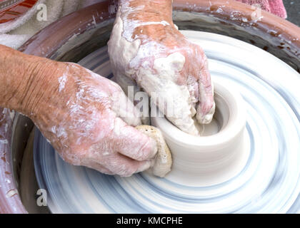 Le mani di una donna più anziana di gettare in ceramica su ceramica ruota Foto Stock