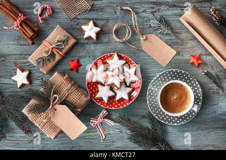 In legno rustico sfondo con tazza di caffè caldo e la confezione regalo di Natale i cookie. Sfondo stagionale ripresa dall'alto. Appartamento laico, vista dall'alto, filtro Foto Stock