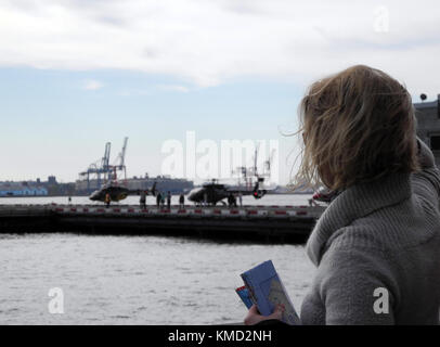 New York, Stati Uniti. 3 novembre 2017. Una donna guarda un sito di decollo e atterraggio per elicotteri utilizzati per i voli turistici a New York, Stati Uniti, 3 novembre 2017. Crediti: Johannes Schmitt-Tegge/dpa/Alamy Live News Foto Stock