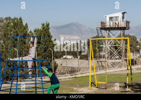 Bambini che giocano in un parco pubblico vicino a una torre di guardia delle Nazioni Unite nella zona cuscinetto settentrionale che separa i lati turco e cipriota della città di Nikosia. Dopo l'occupazione di Cipro da parte delle truppe turche nel 1974, Nikosia fu separata in due zone, la Turchia controllava il lato nord e Cipro il sud. 3 dicembre 2017. Crediti: Celestino Arce/ZUMA Wire/Alamy Live News Foto Stock