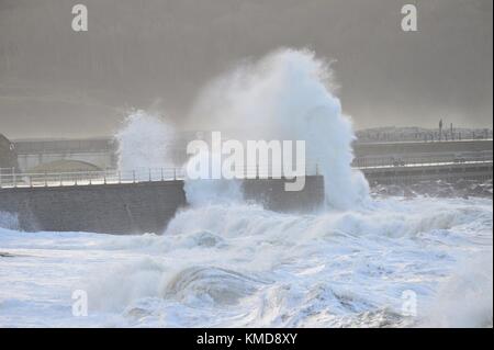 Aberystwyth Wales UK, Giovedi 07 Dicembre 2017 UK Meteo: Il confine meridionale di Storm Caroline, con venti che guastano tra i 40 e i 60 mph, porta enormi onde che si schiantano nelle difese marine di Aberystwyth, Ceredigion , Galles occidentale UK. Nei prossimi giorni è previsto un clima molto freddo e vinoso, con forti condizioni di neve e ghiaccio che si diffondono da nord. MET Office sono stati emessi avvertimenti 'gialli', e vi è il rischio di perturbare i viaggi in molte aree foto © Keith Morris/ Alamy Live News Foto Stock